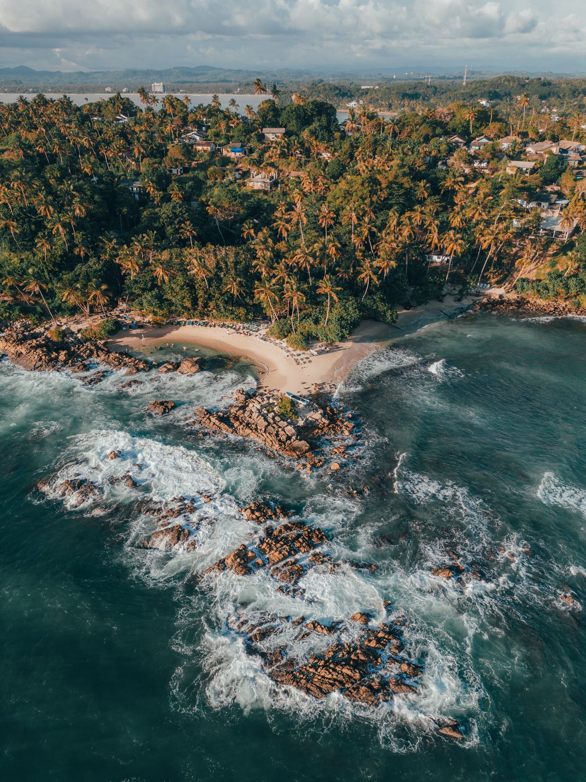 Aerial of the palm-fringed cove and reef at Mirissa, southern Sri Lanka